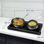 Hornilla eléctrica doble Black+Decker DB1002B color negro con dos quemadores tipo espiral y medidas 57.7 cm x 29 cm x 13.8 cm en encimera de cocina.