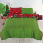 Reverso verde liso del cubrecama reversible Bouquetex; frente rojo con estrellas y copos dorados; toma frontal sobre cama; tallas Full/Queen y King; incluye 2 fundas.