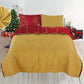 Reverso mostaza liso del cubrecama navideño reversible Bouquetex Colección Elfo; frente rojo con árboles y copos dorados; fotografía en dormitorio, acolchado de guata; tallas Full/Queen 218×224 cm y King 264×224 cm; juego con dos fundas.