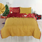 Reverso mostaza liso del cubrecama navideno reversible Bouquetex Coleccion Elfo; frente rojo con “Merry Christmas” y esfera dorada; relleno de guata; tallas Full/Queen 218×224 cm y King 264×224 cm; 2 fundas coordinadas.