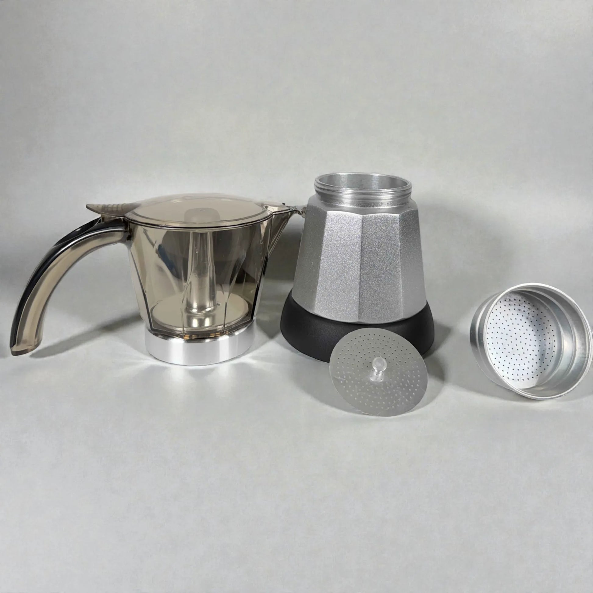 Componentes de cafetera moka eléctrica MOKA 3–6 tazas en fondo claro: jarra superior con asa, caldera inferior plateada, filtro/placa y embudo.