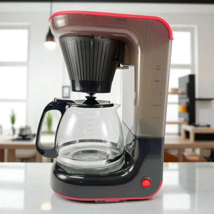 Cafetera Taurus Velvet Coffee de 1.2 litros para 12 tazas, color negro con detalles rojos, vista lateral mostrando jarra de vidrio y filtro permanente.