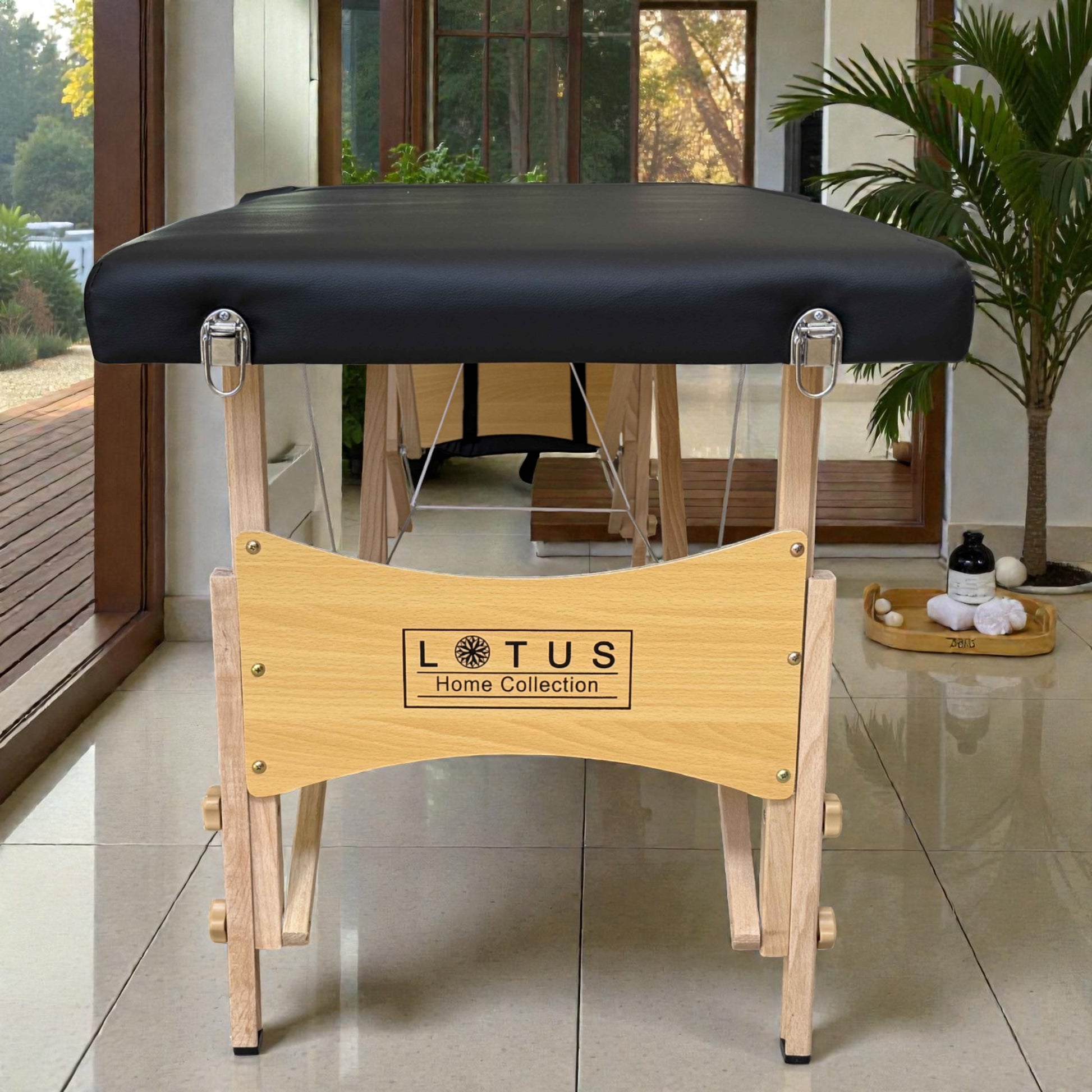 Vista frontal de la cama de masaje plegable Lotus, mostrando panel de madera con logotipo Lotus Home Collection y patas de madera clara con herrajes metálicos.