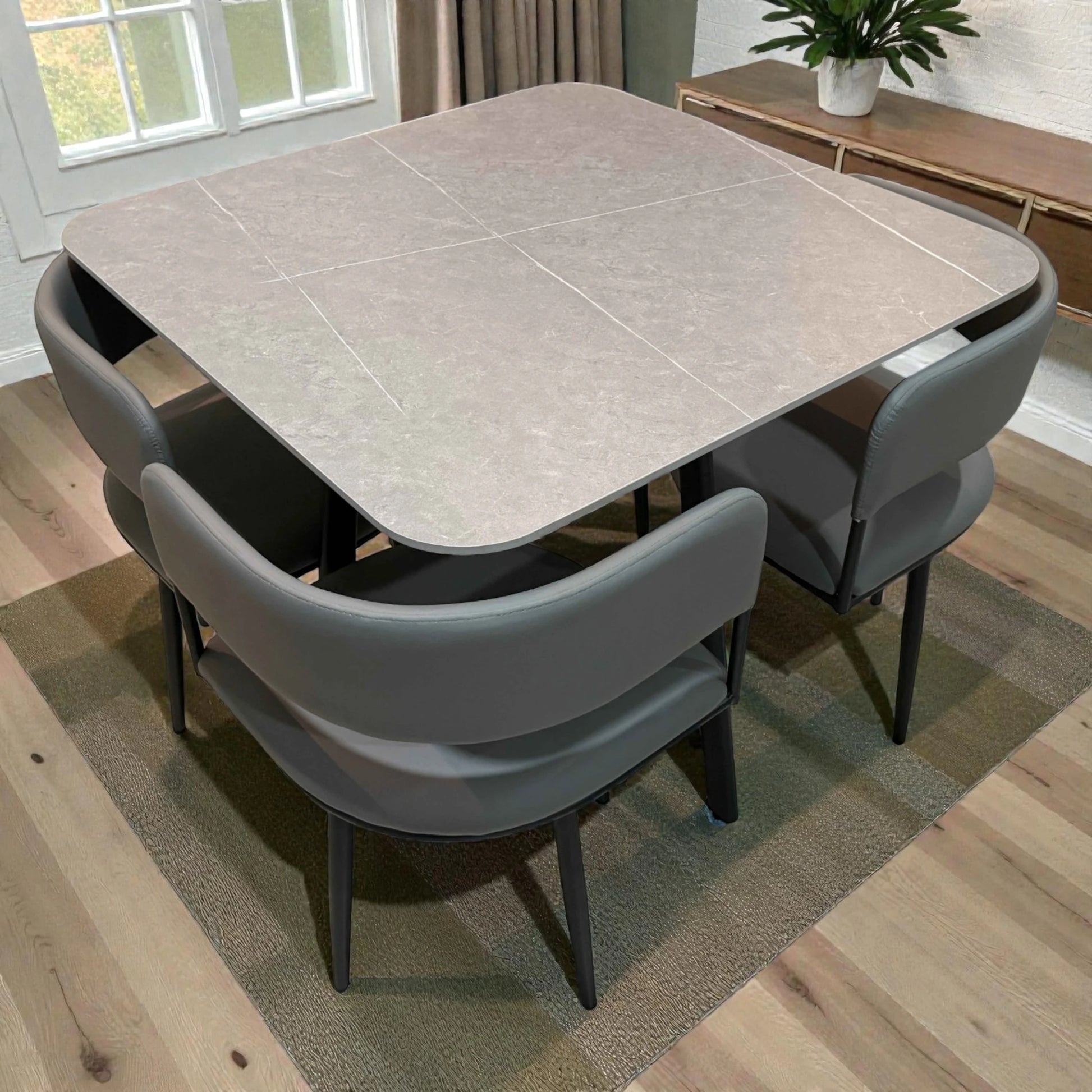 Comedor de 4 personas Ambienta Home Decor SKU 41389 con mesa cuadrada 90x90 en color gris piedra y 4 sillas grises, vista diagonal trasera
