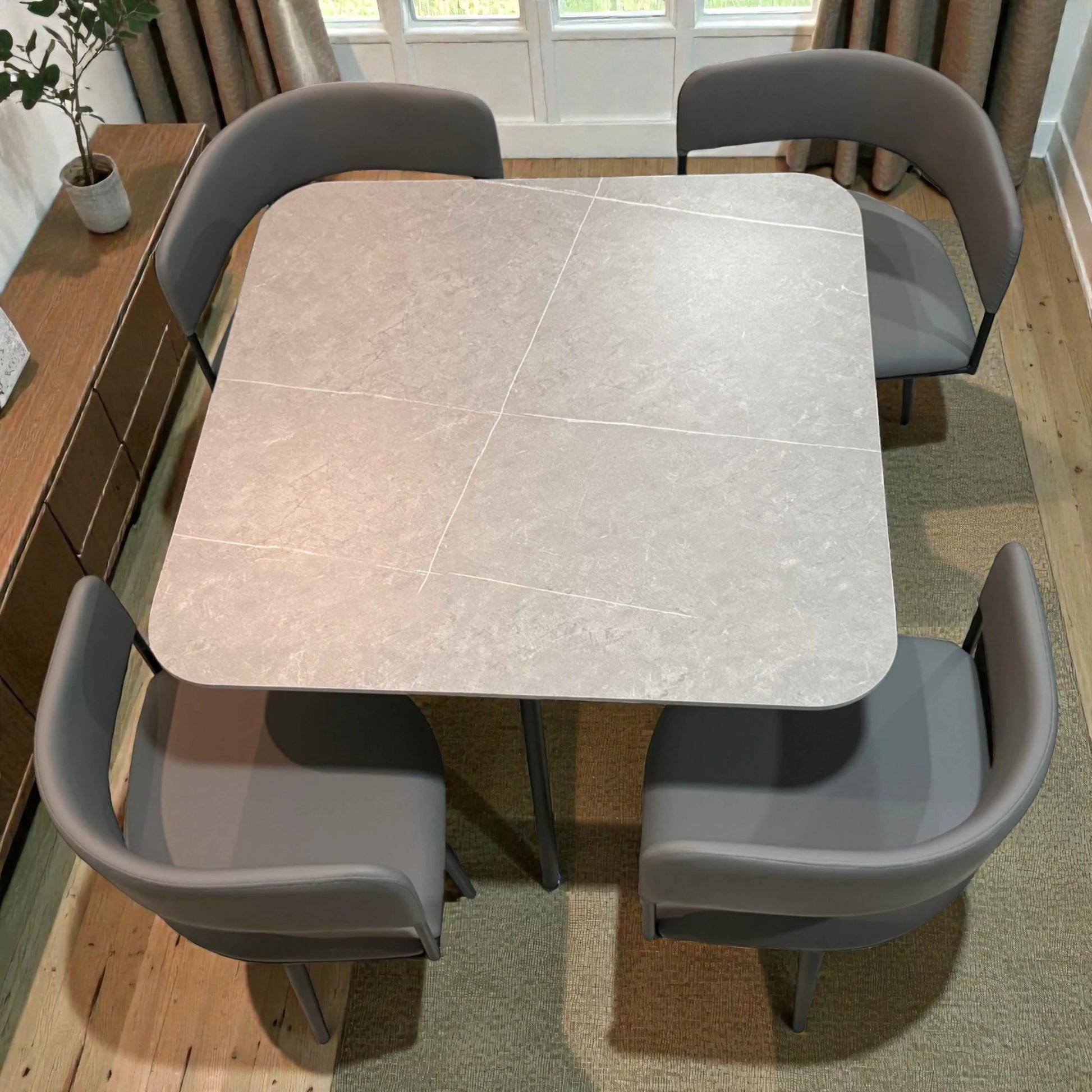 Vista superior centrada de comedor para 4 personas SKU 41389 con mesa 90x90 en acabado gris claro tipo piedra y sillas grises