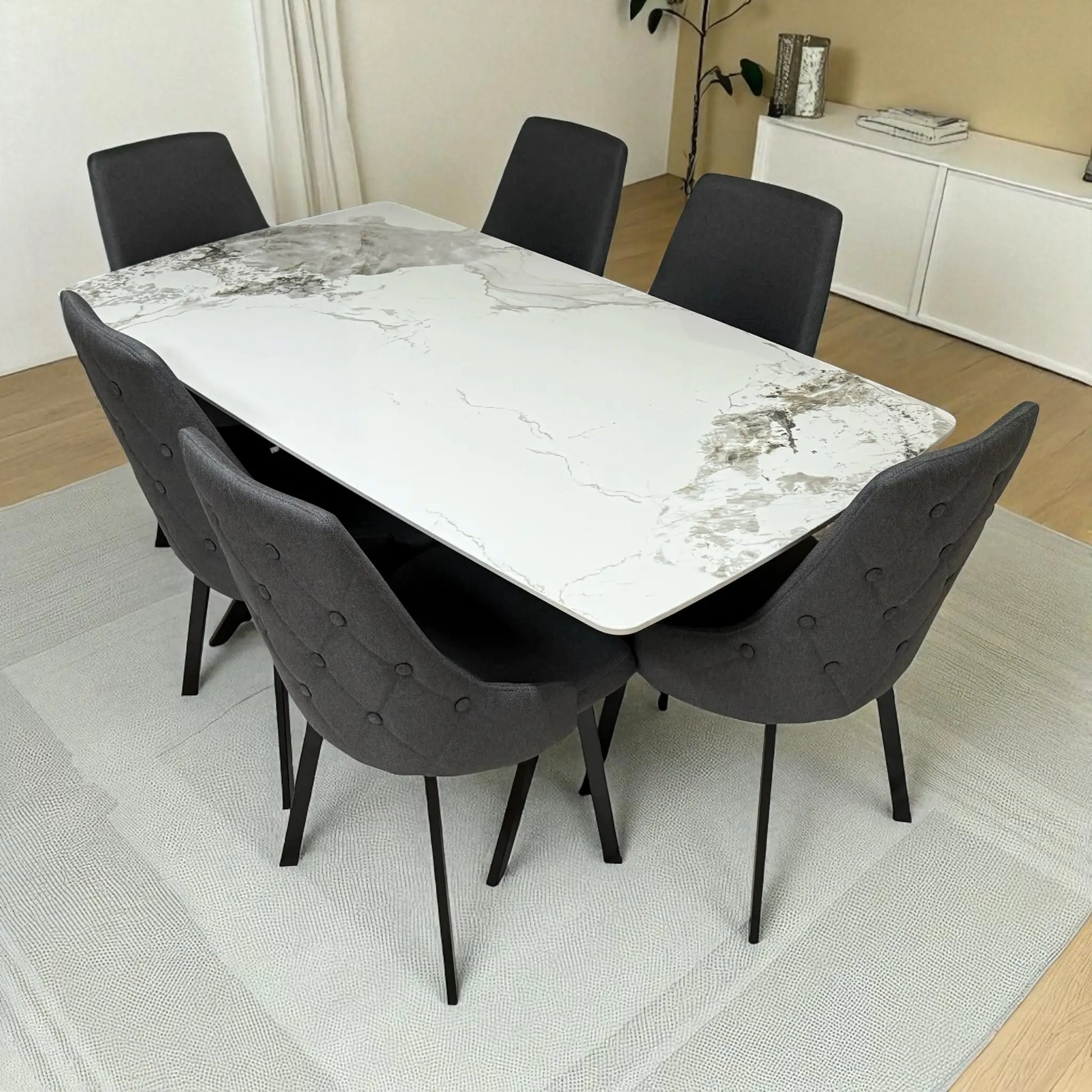 Vista izquierda del comedor Ambienta DT-06-2237 con mesa rectangular efecto mármol blanco y seis sillas tapizadas gris oscuro con patas negras.