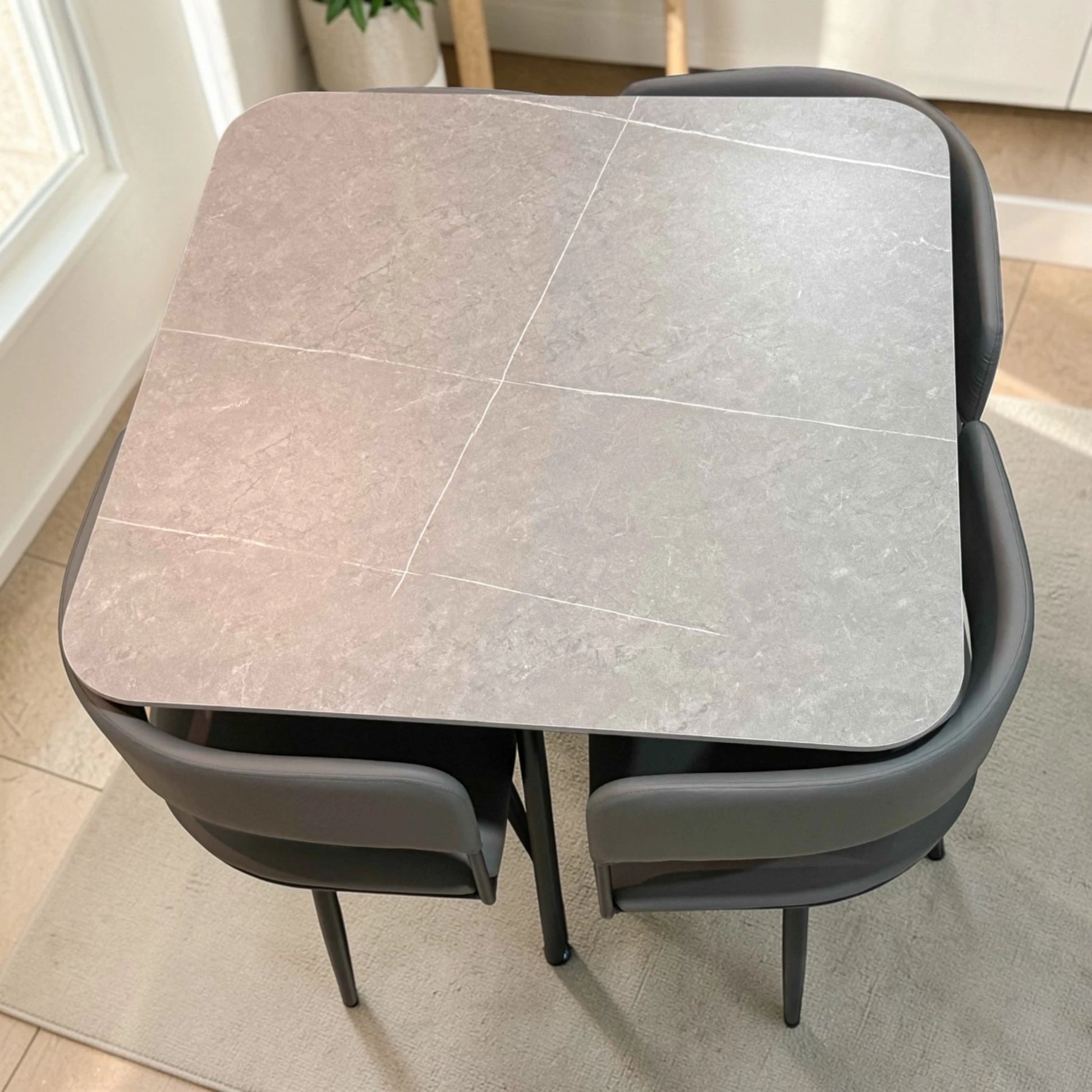 Comedor compacto para 4 personas SKU 41389 con mesa cuadrada 90x90 gris piedra y sillas grises parcialmente integradas bajo la mesa