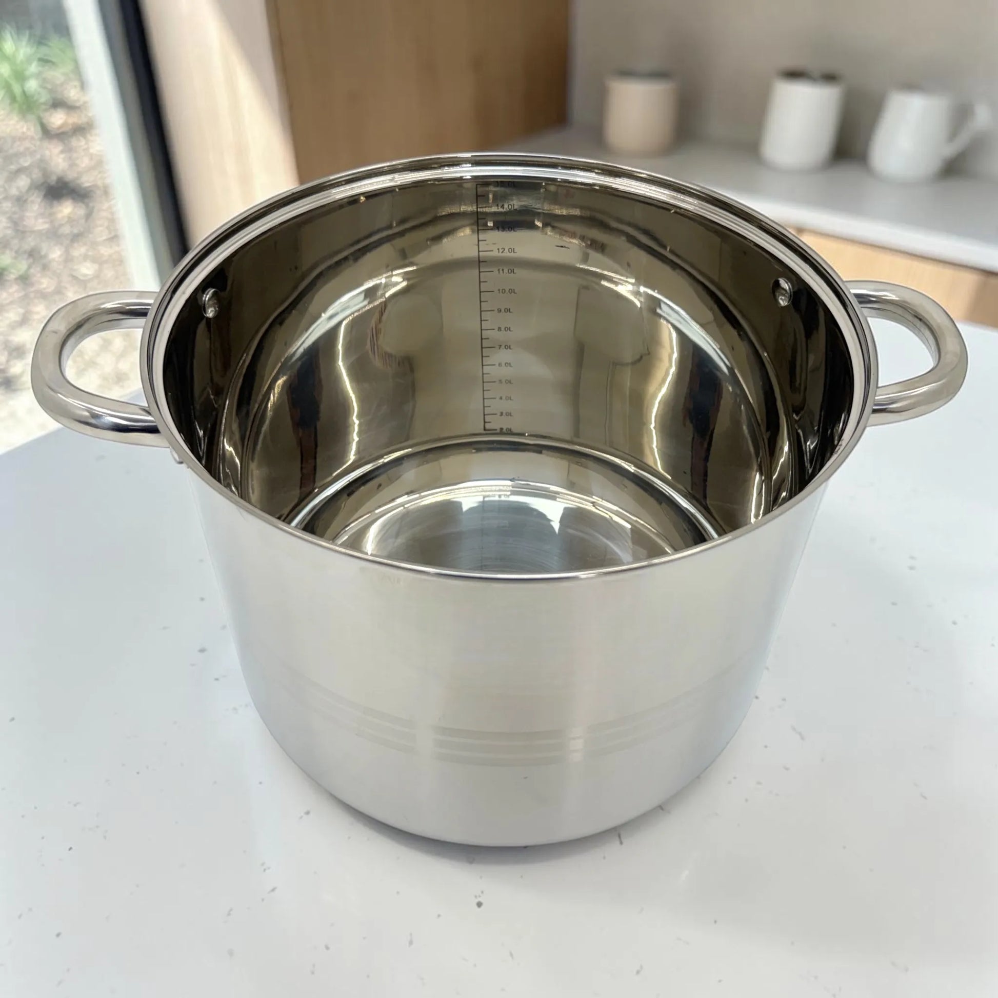 Olla grande Crystal Cuisine CC-138 de acero inoxidable con interior brillante y medidor interno de capacidad, presentada sin tapa sobre encimera blanca.