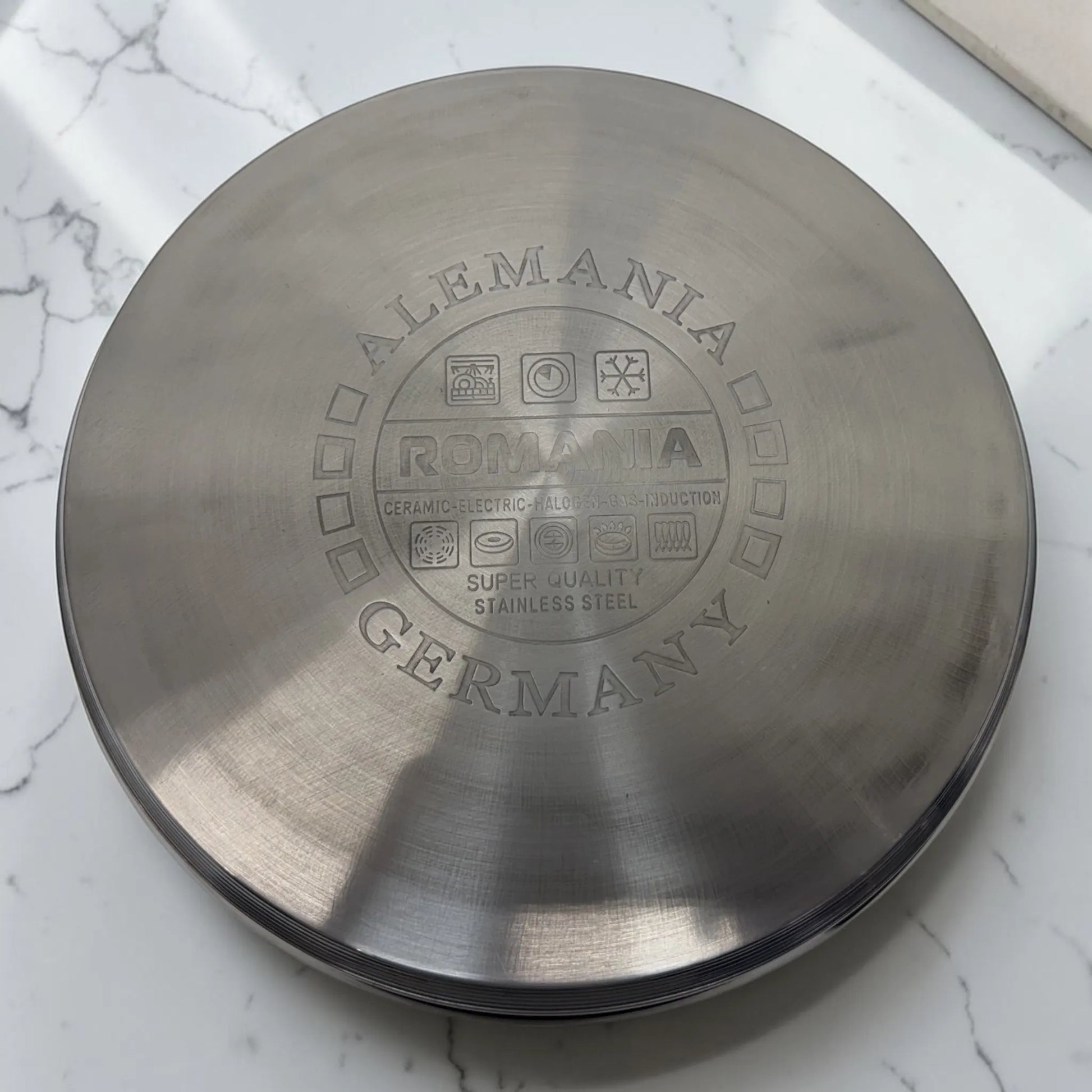 Detalle cerrado de la base de una olla Romania con grabado Germany y Super Quality Stainless Steel.