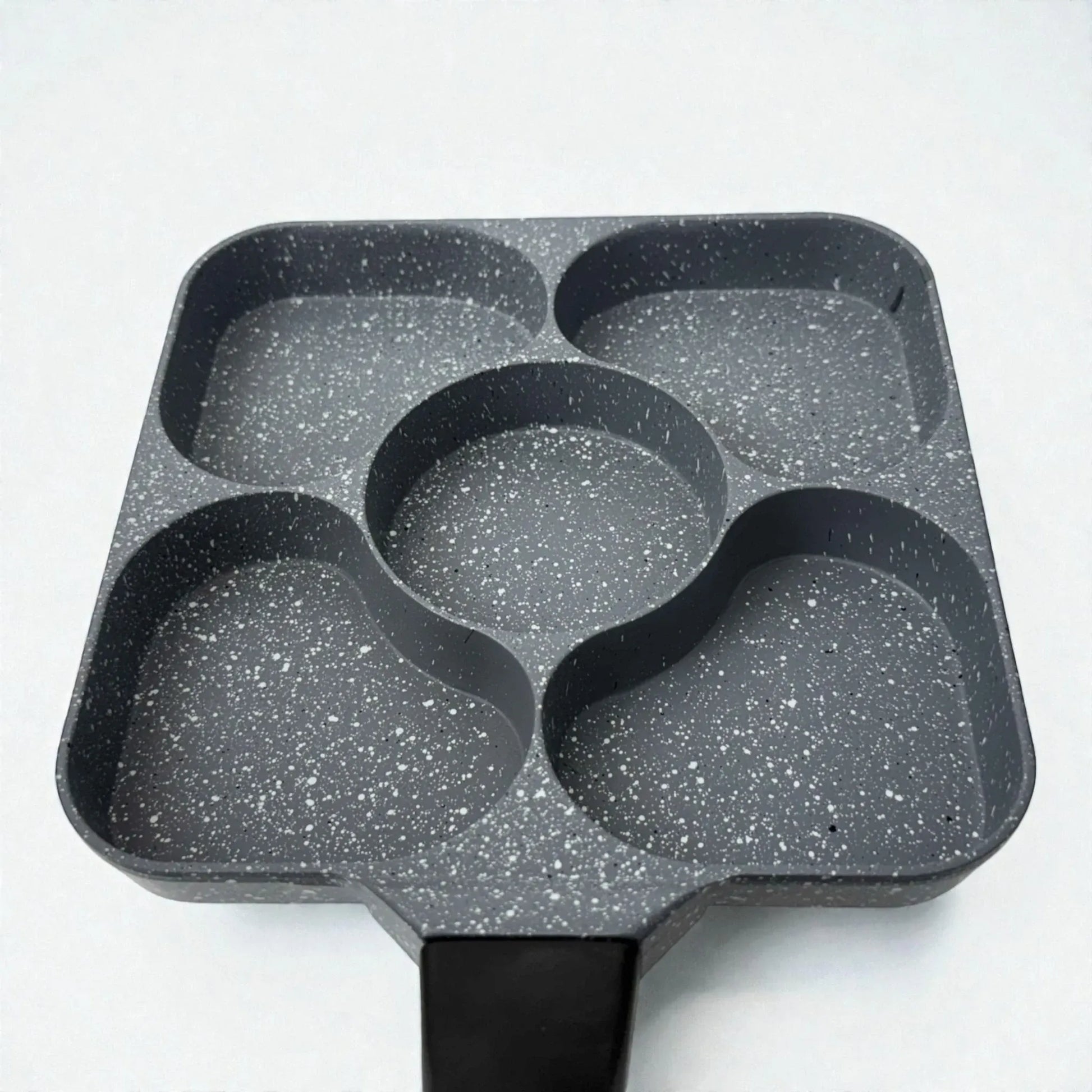 Detalle del interior del sarten Synamore 5 en 1 antiadherente en acabado gris moteado, con cinco compartimentos separados y mango negro, sobre fondo blanco.