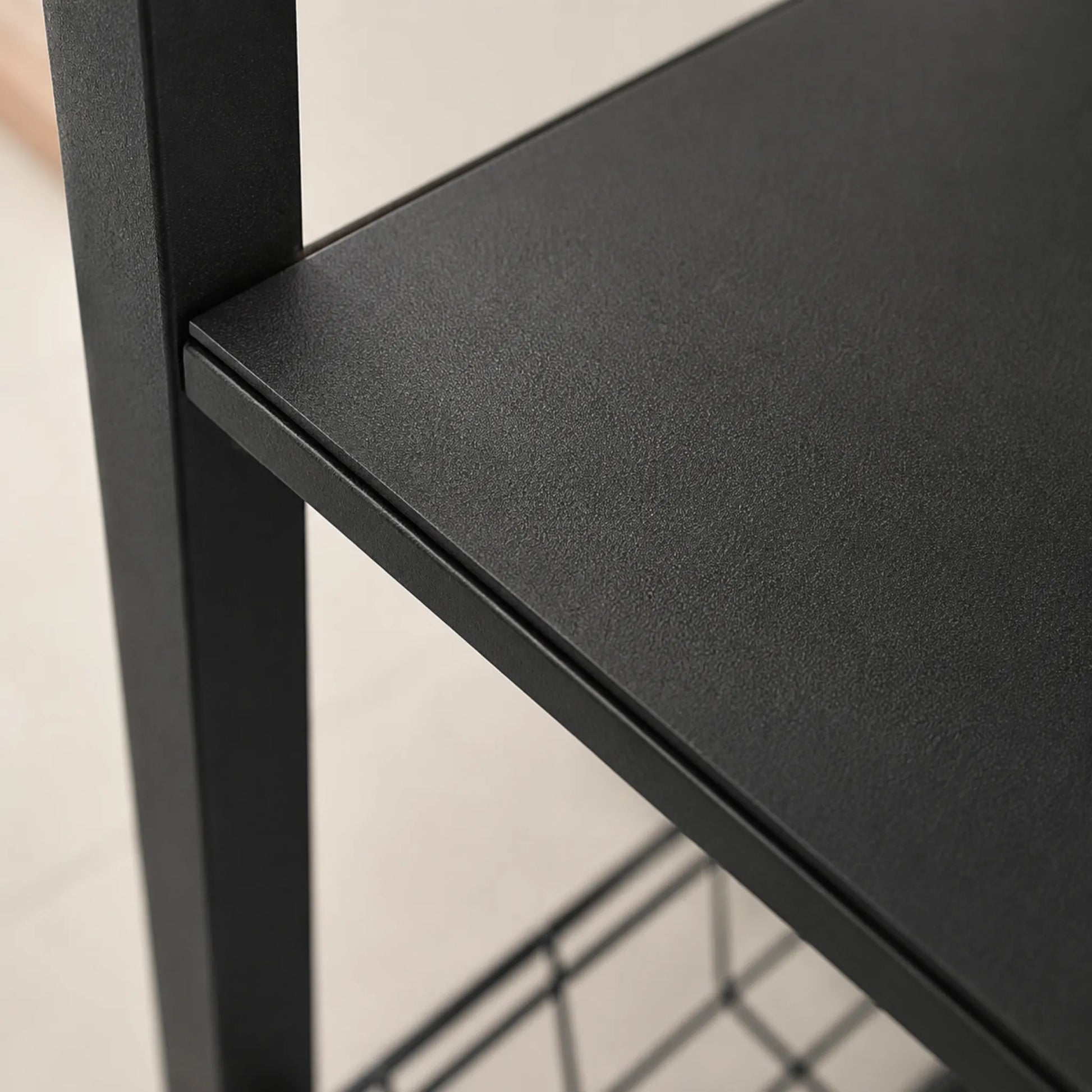 Primer plano de la repisa metálica negra del organizador de cocina Ambienta Home Decor mostrando el acabado texturizado resistente y la estructura de acero.