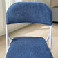 Detalle del tapizado azul en respaldo y asiento de silla plegable CH-3023-BLU con estructura blanca.