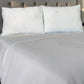 Dos almohadas de bambú Pacific Home blancas colocadas juntas en una cama, mostrando cómo se ven instaladas en un dormitorio.