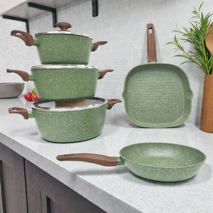 Set de ollas Epicure by Joseph Marcus Olive Collection color verde oliva con recubrimiento antiadherente, tres ollas con tapa de vidrio, sartén redondo y sartén parrilla cuadrado, foto lifestyle sobre encimera de cocina.