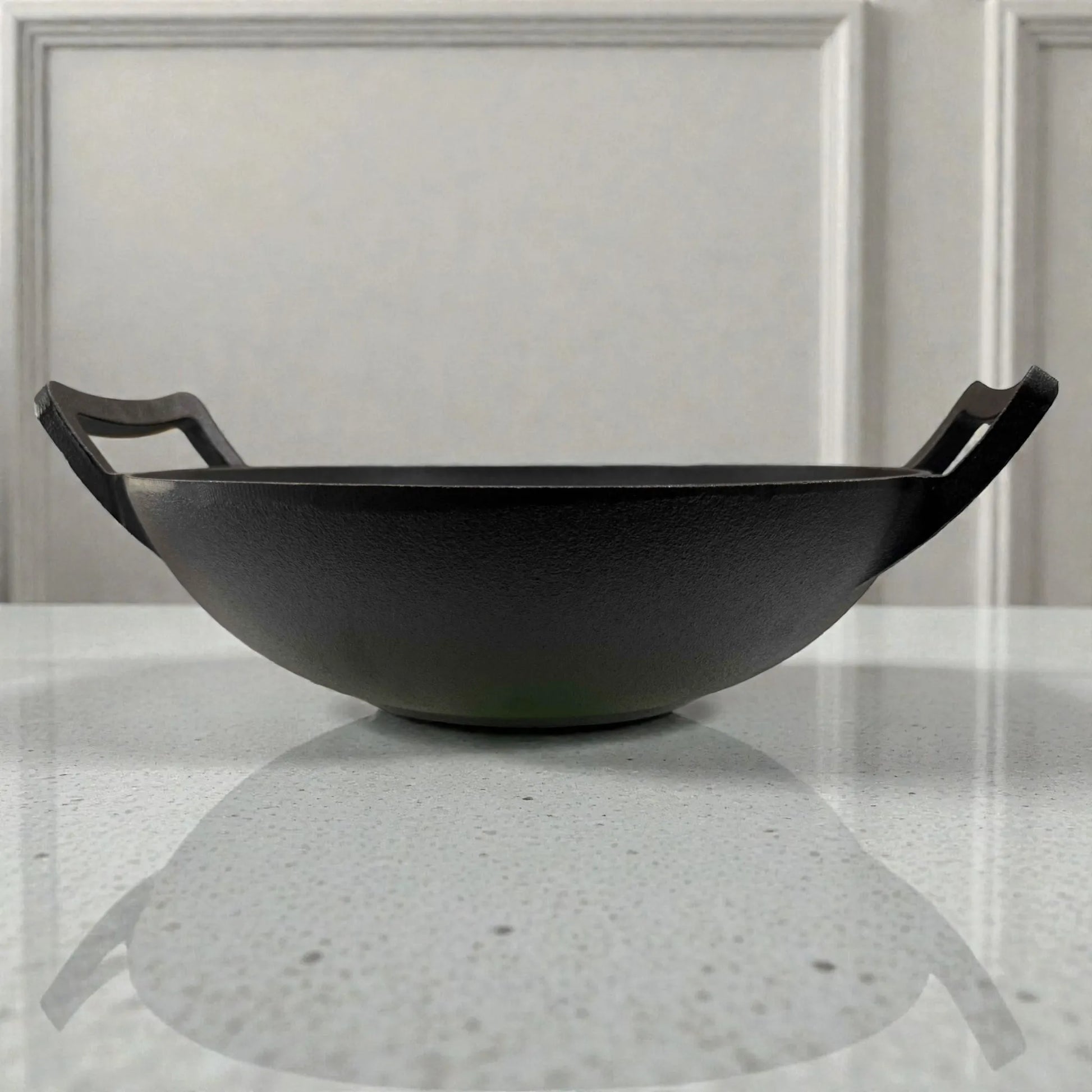 Wok de hierro fundido Epicure by Joseph Marcus negro de 31 cm, vista lateral de perfil que muestra la profundidad del wok y sus dos asas.