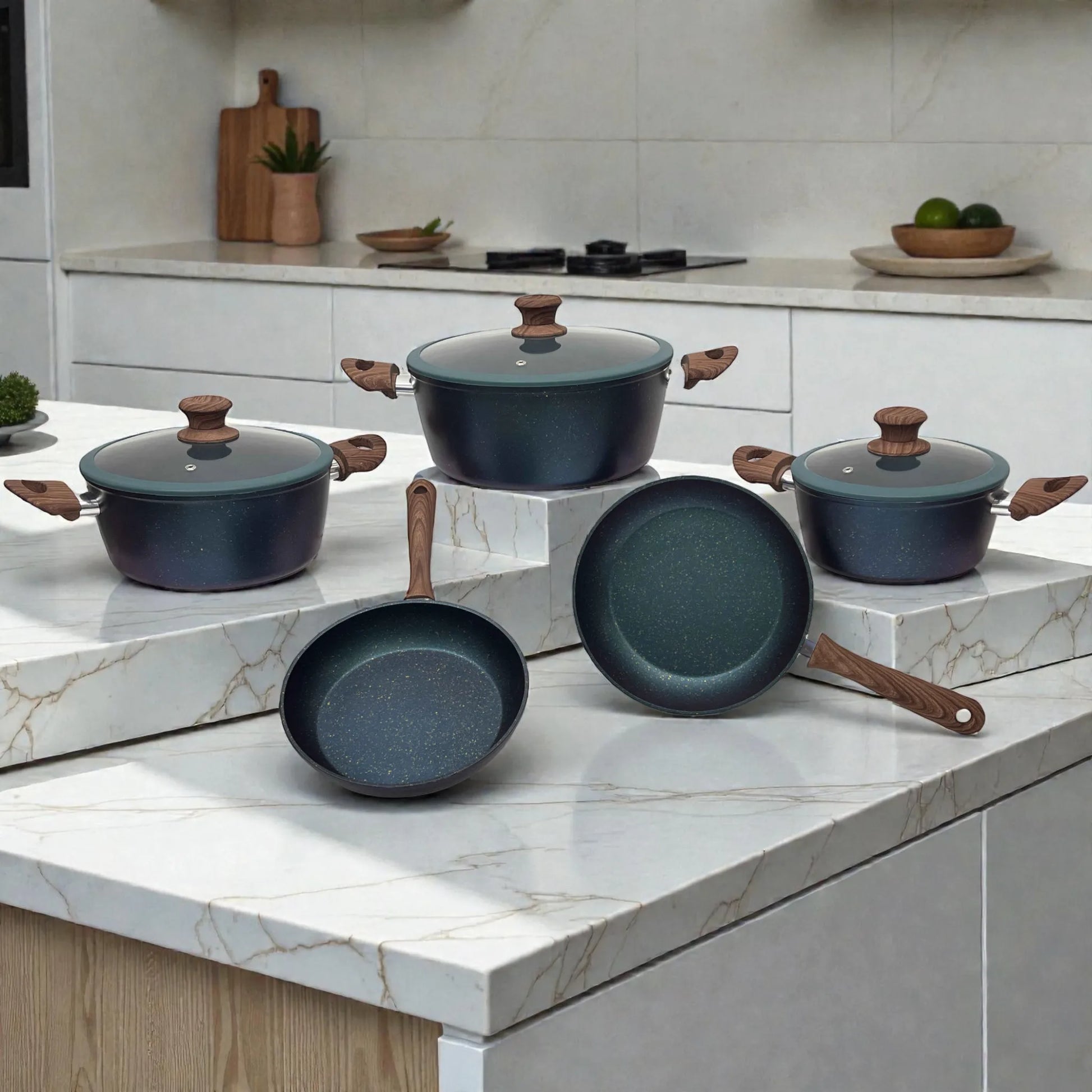 Juego de ollas Epicure Zafiro 8 piezas: 3 ollas con tapa de vidrio (20 cm, 24 cm, 28 cm) y 2 sartenes antiadherentes (22 cm y 24 cm) en cocina moderna, color azul oscuro moteado con mangos tipo madera.