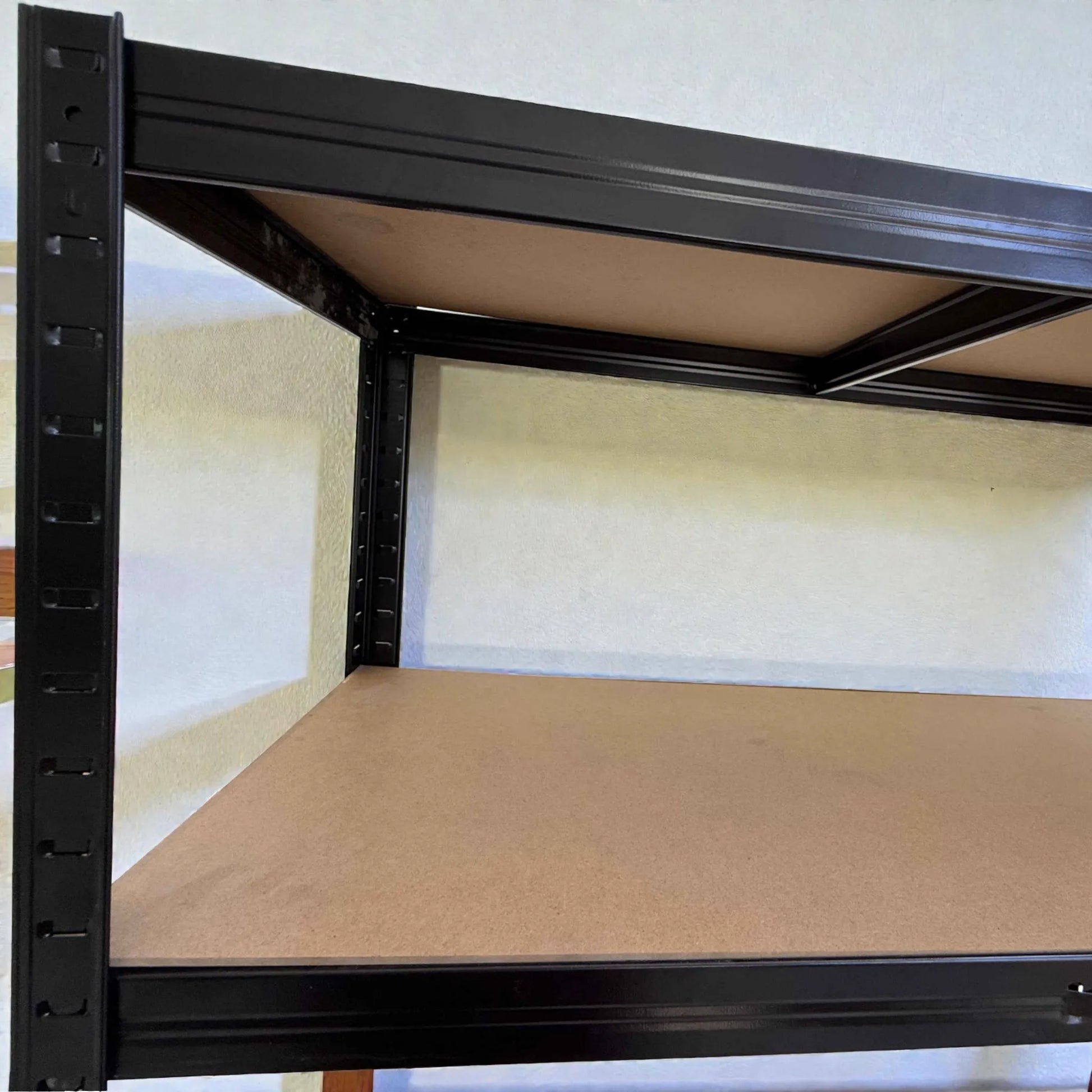 Detalle de la estructura metálica negra del estante Lotus de 5 niveles, mostrando uniones, perforaciones y refuerzos bajo la repisa de MDF.