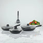 Tres sartenes Estrella Gourmet con tapas de vidrio y espátula colgada, acabado exterior negro e interior gris marmolizado.