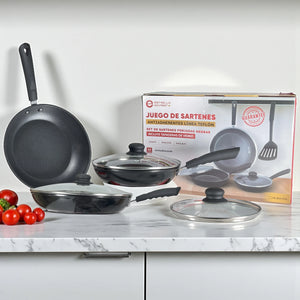 Juego de sartenes Estrella Gourmet de aluminio forjado negro con recubrimiento antiadherente de teflón, 7 piezas (20, 24 y 30 cm) con tapas de vidrio; vista principal con caja.
