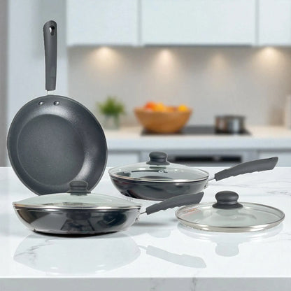 Juego de tres sartenes Estrella Gourmet en cocina moderna; 20, 24 y 30 cm, color negro, antiadherente teflón, con dos tapas colocadas y una tapa aparte; mangos de baquelita.