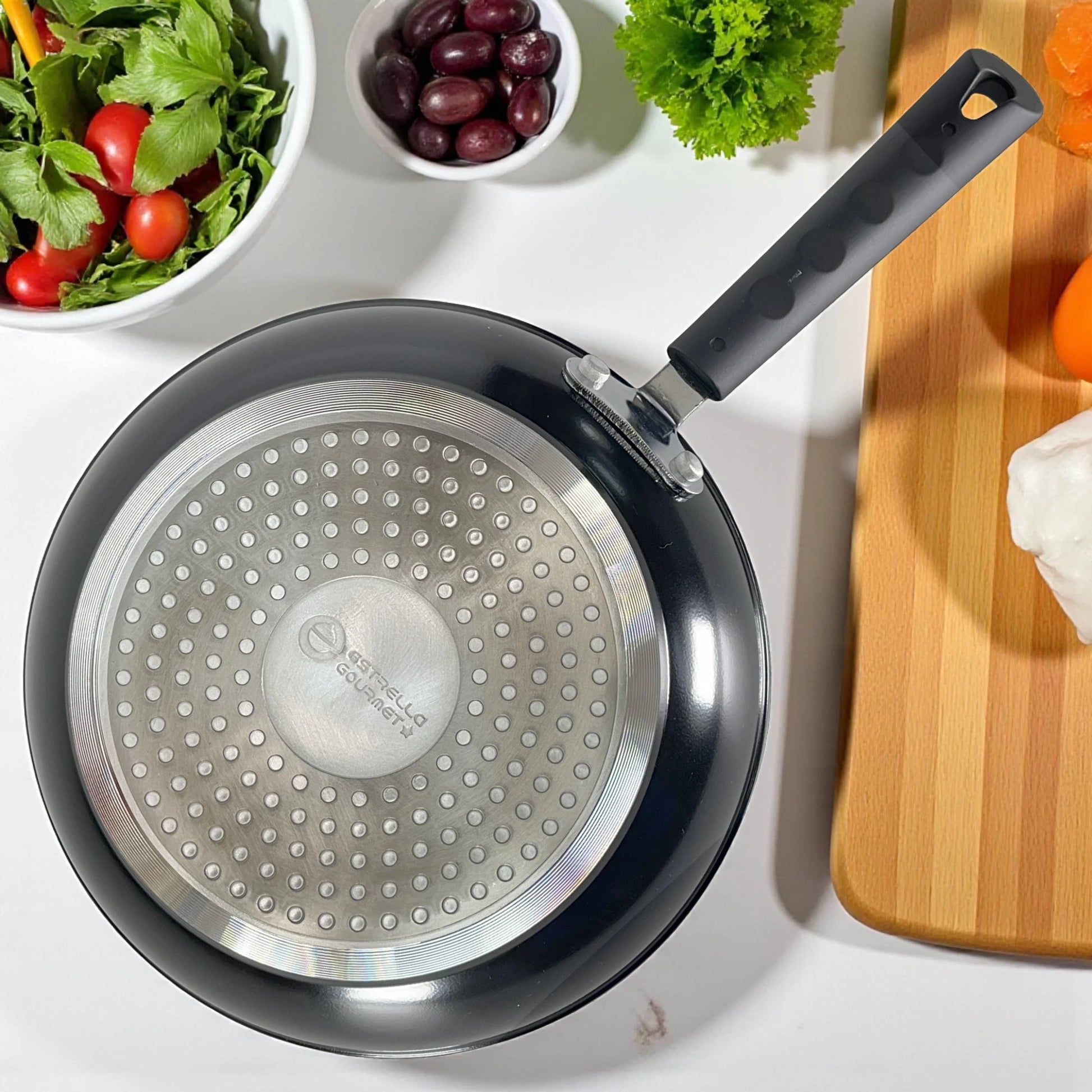 Vista superior de la base difusora compatible con inducción del sartén Estrella Gourmet de 30 cm, aluminio forjado, exterior negro y mango ergonómico.