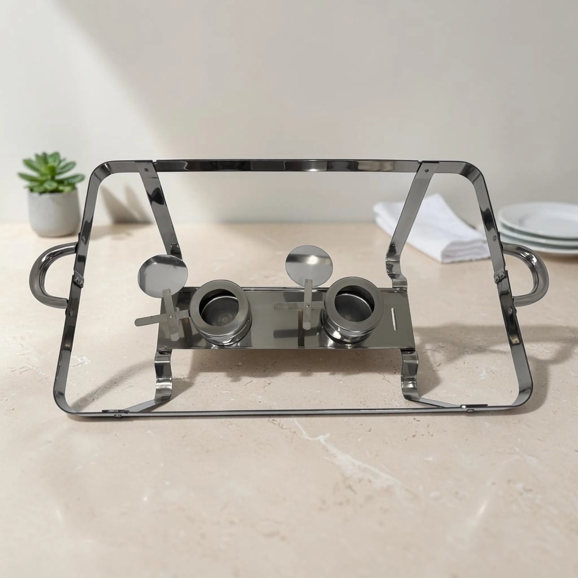 Estructura metálica de chafing dish en acero inoxidable con dos quemadores y asas laterales para catering.