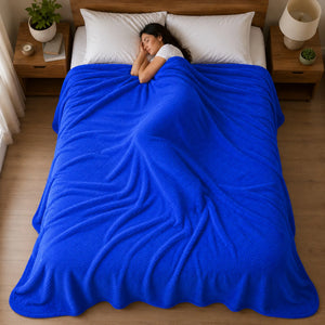 Persona durmiendo cubierta con una frazada Colven azul rey de 190 x 190 cm sobre una cama matrimonial.