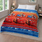 Frazada piel de borrego infantil Cars con Lightning McQueen, tonos naranja y azul, 230x190 cm y 1500 g, extendida sobre cama; diseño con carros de carrera, franjas y detalles tipo pista.