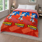 Frazada piel de borrego infantil Sonic Prime color rojo y naranja, tamaño 230x190 cm y peso 1500 gramos, colocada sobre cama; diseño repetido de Sonic azul con logotipo “Sonic Prime”, vista en dormitorio.