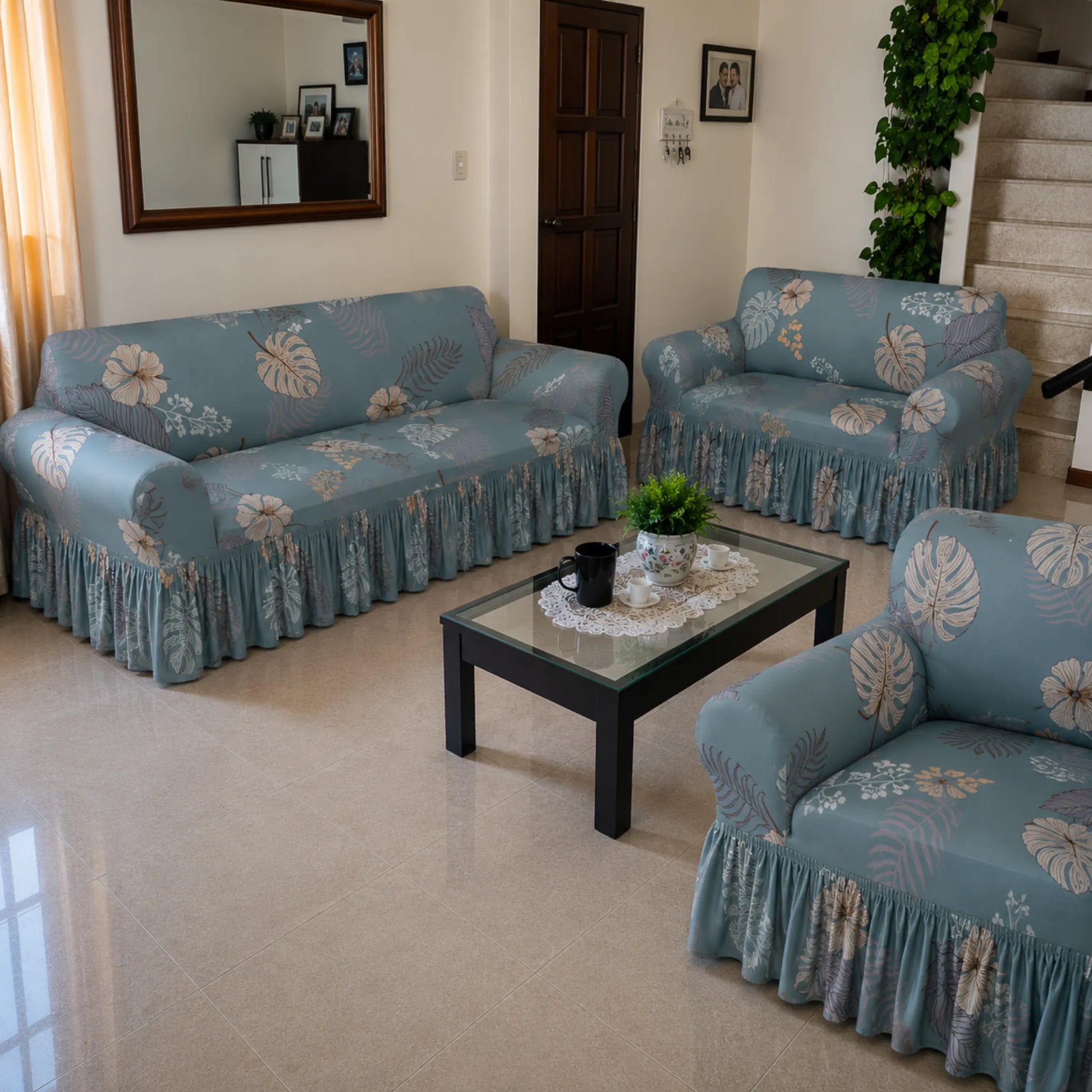 Fundas para sala Home Care Hawaii diseño Tropical Celeste, set para sofá de 3, 2 y 1 asiento en color celeste con hojas y flores tropicales en tonos beige y gris.