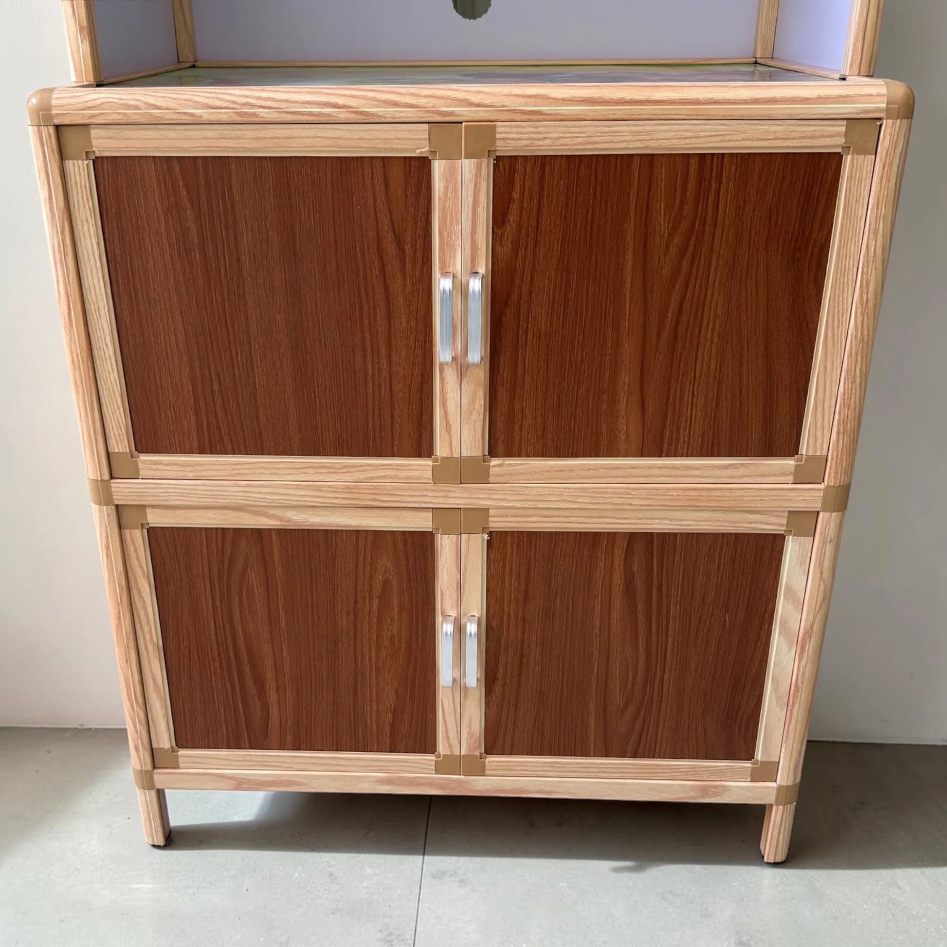 Detalle de las puertas inferiores del gabinete de cocina LHC-RAC12-2, con almacenamiento cerrado y acabado en color café nogal con marco en tono madera natural.
