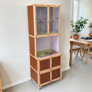 Gabinete de cocina multiusos LHC-RAC12-2 de Ambienta Home Decor en color madera natural y café, vista frontal en ambiente, con vitrina superior de vidrio decorado, espacio central abierto y compartimentos inferiores, tamaño 64 x 44 x 175 cm.