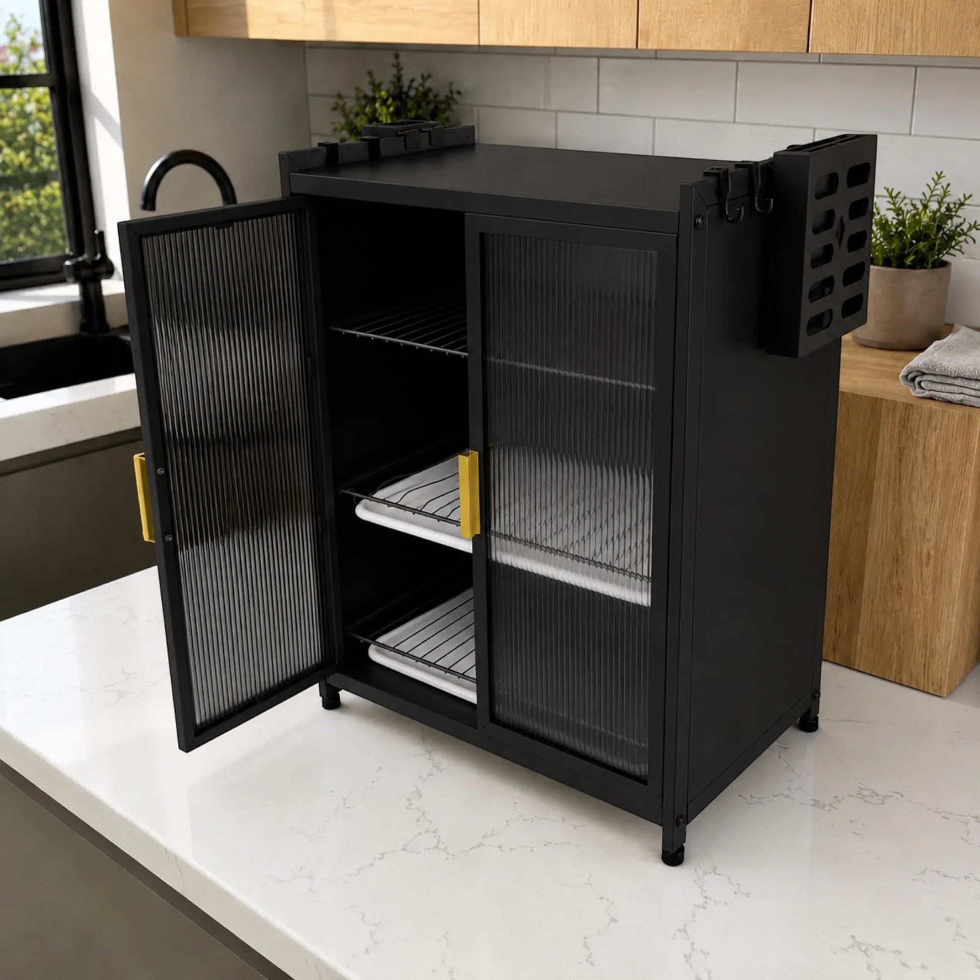 Gabinete organizador de platos KC-801 Ambienta color negro, visto en ángulo con puertas translúcidas abiertas, rejillas negras, dos bandejas de drenaje blancas, porta cuchillos lateral y jaladeras doradas.