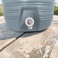 Detalle frontal del grifo blanco del dispensador térmico Princeware gris de 17 litros SKU 3554 para servir agua o bebidas frías.