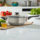 Sartén Hoffavorer de 24 cm (3.4 L) en acero inoxidable 18-10 con recubrimiento antiadherente Xylan Plus, tapa de vidrio, mango largo negro y asa auxiliar; vista lateral sobre encimera de cocina.