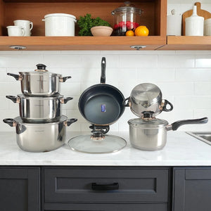 Vista del set Hoffavorer HF-4441: a la izquierda cacerolas apiladas, al centro sartén 24 cm mostrando antiadherente Xylan Plus, tapa grande delante y a la derecha cazo 16 cm; acero inoxidable 18/10, asas negras, apto inducción.