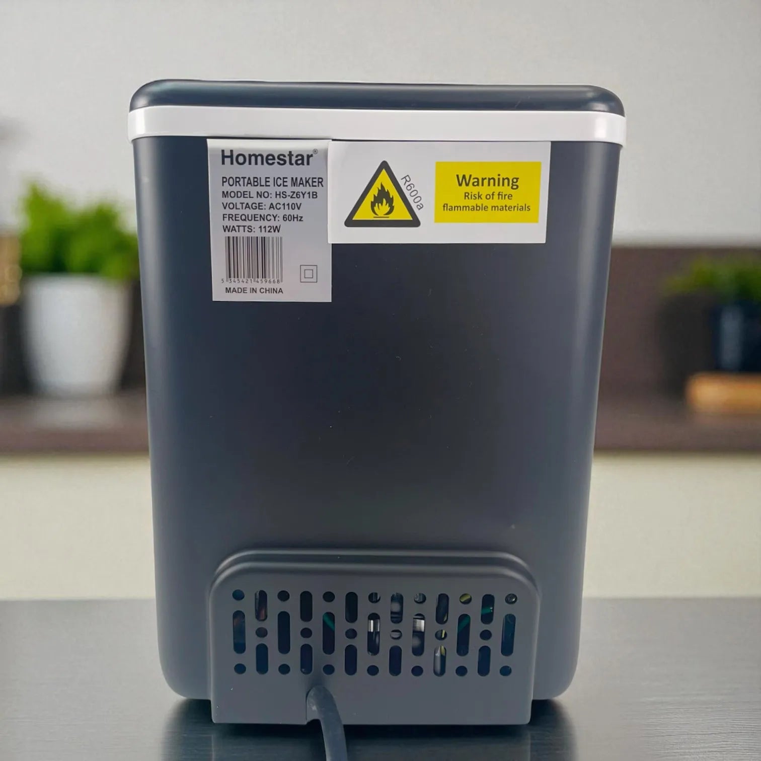 Parte trasera de la Homestar HS-Z6Y1B con etiqueta de modelo, 110 V 60 Hz 112 W y adhesivo de advertencia; salida del cable en la base.
