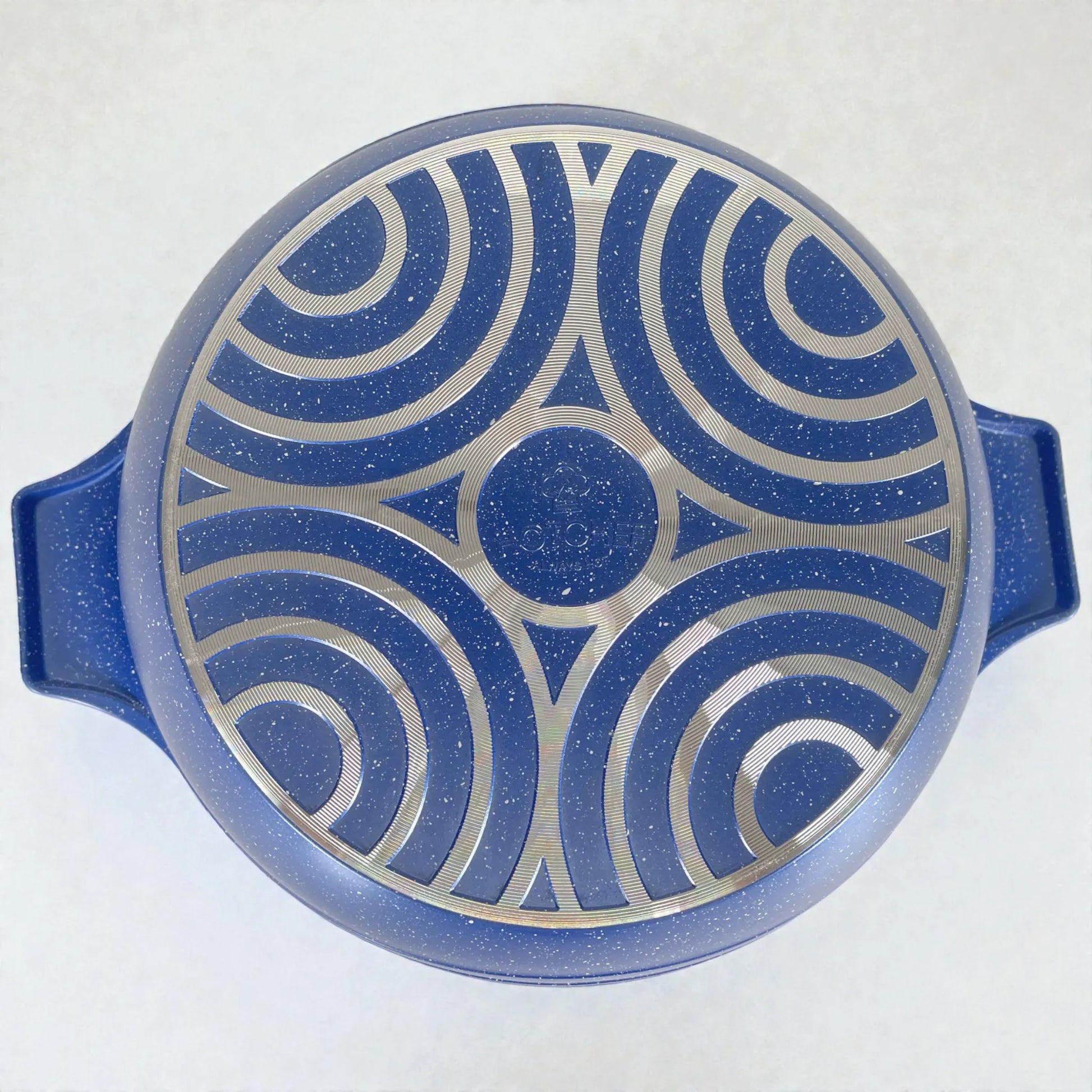 Base inferior de olla HotChef granito azul con patrón circular metálico tipo difusor de calor, vista inferior centrada mostrando el fondo y las asas.