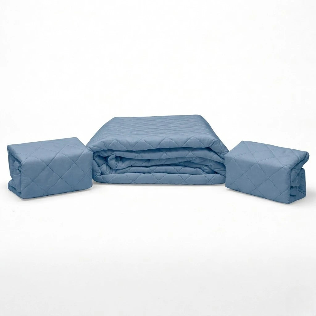 Set de cubrecama HPC Polo color azul acero doblado sobre fondo blanco con piezas acomodadas a ambos lados.