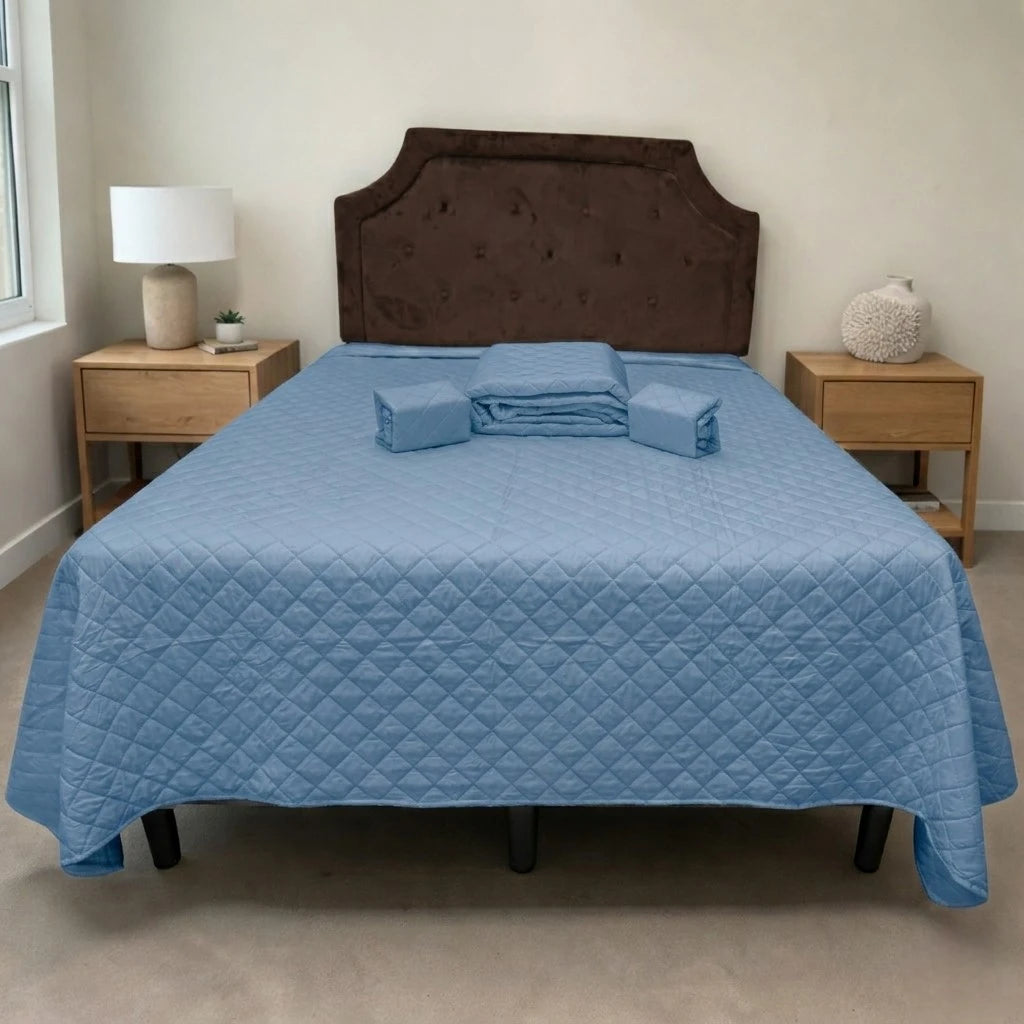 Set de cubrecama HPC Polo color azul acero sobre cama, vista frontal con piezas dobladas colocadas al centro.