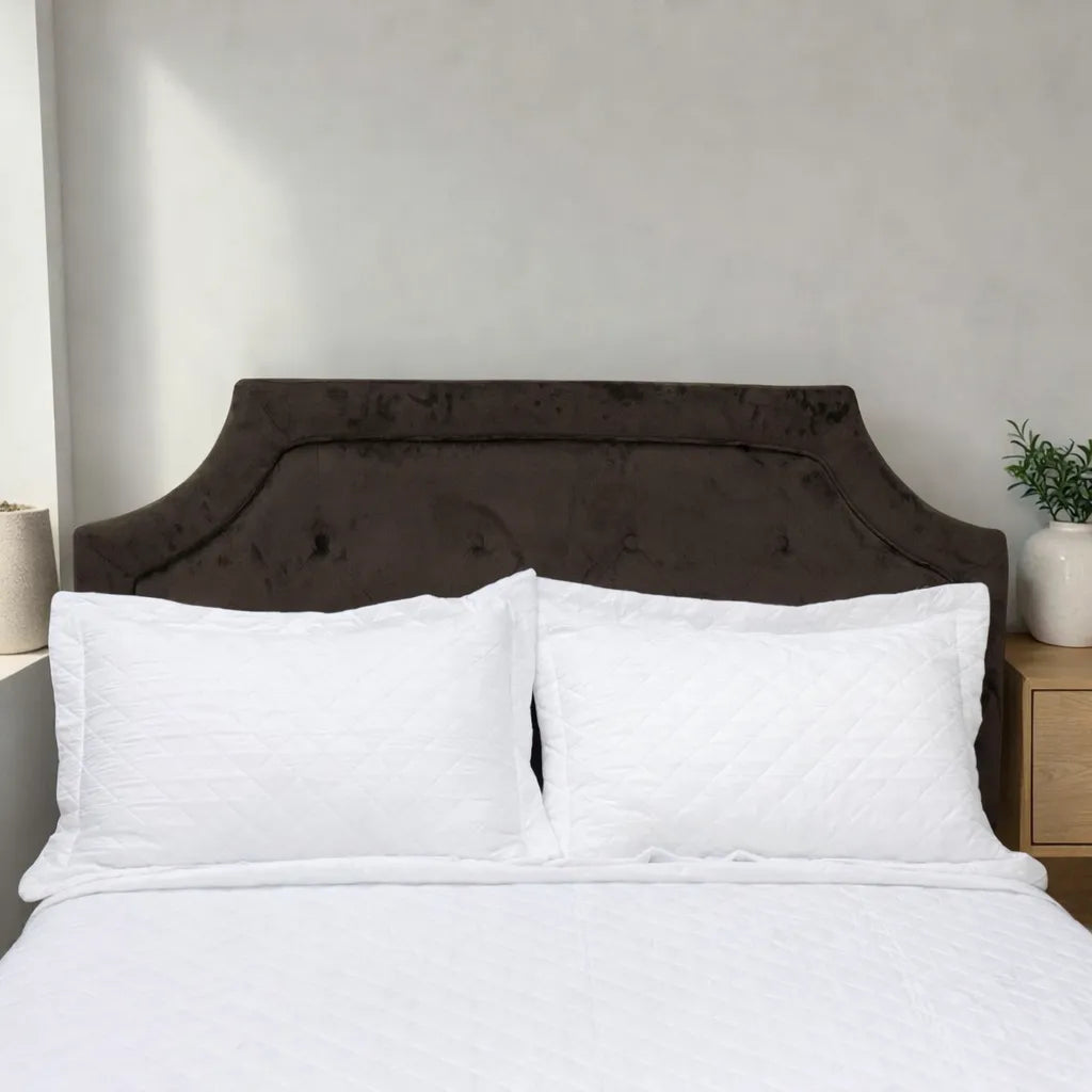 Acercamiento del cubrecama HPC Polo blanco con dos fundas de almohada acolchadas sobre cama.