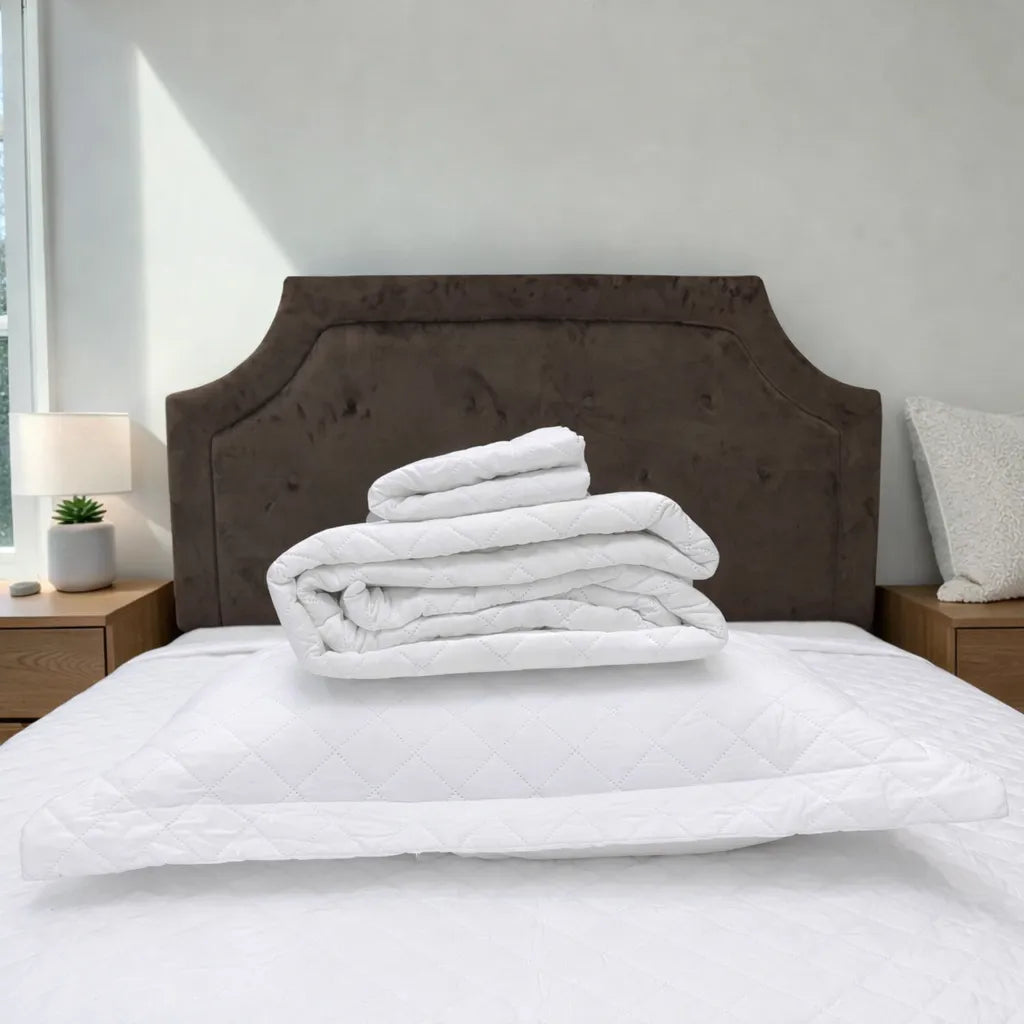 Cubrecama HPC Polo blanco doblado sobre almohada blanca, mostrando su textura acolchada y presentación del set.