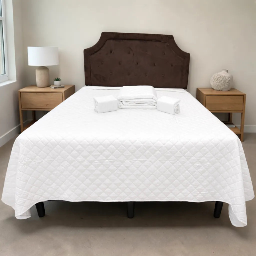 Set de cubrecama HPC Polo blanco sobre cama, vista frontal con piezas dobladas colocadas al centro.