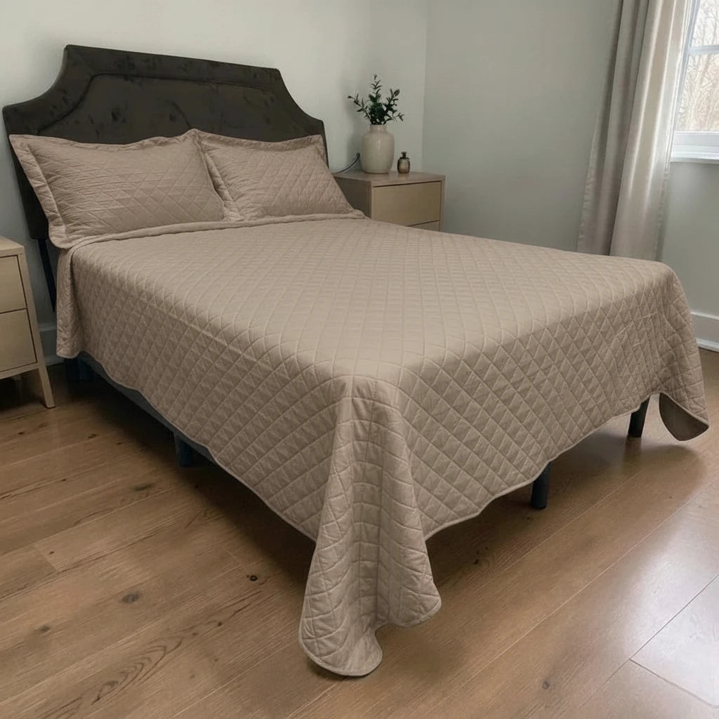 Cubrecama HPC Polo color camel acolchado, vista lateral sobre cama con dos fundas de almohada del mismo color.