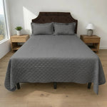 Cubrecama HPC Polo color gris de microfibra acolchada sobre cama, vista frontal con dos fundas de almohada a juego.