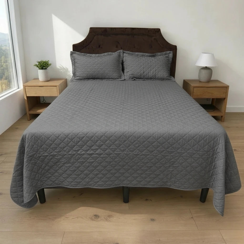 Cubrecama HPC Polo color gris de microfibra acolchada sobre cama, vista frontal con dos fundas de almohada a juego.