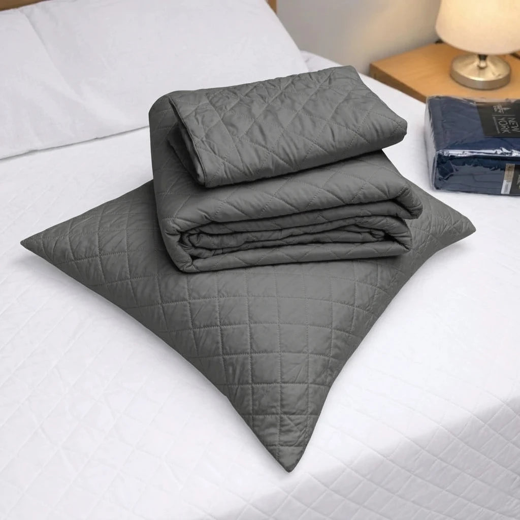 Detalle del cubrecama HPC Polo color gris doblado sobre almohada, con diseño acolchado y acabado de microfibra.