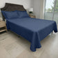 Cubrecama HPC Polo color navy sobre cama, vista lateral derecha en dormitorio con ventana y fundas de almohada a juego.