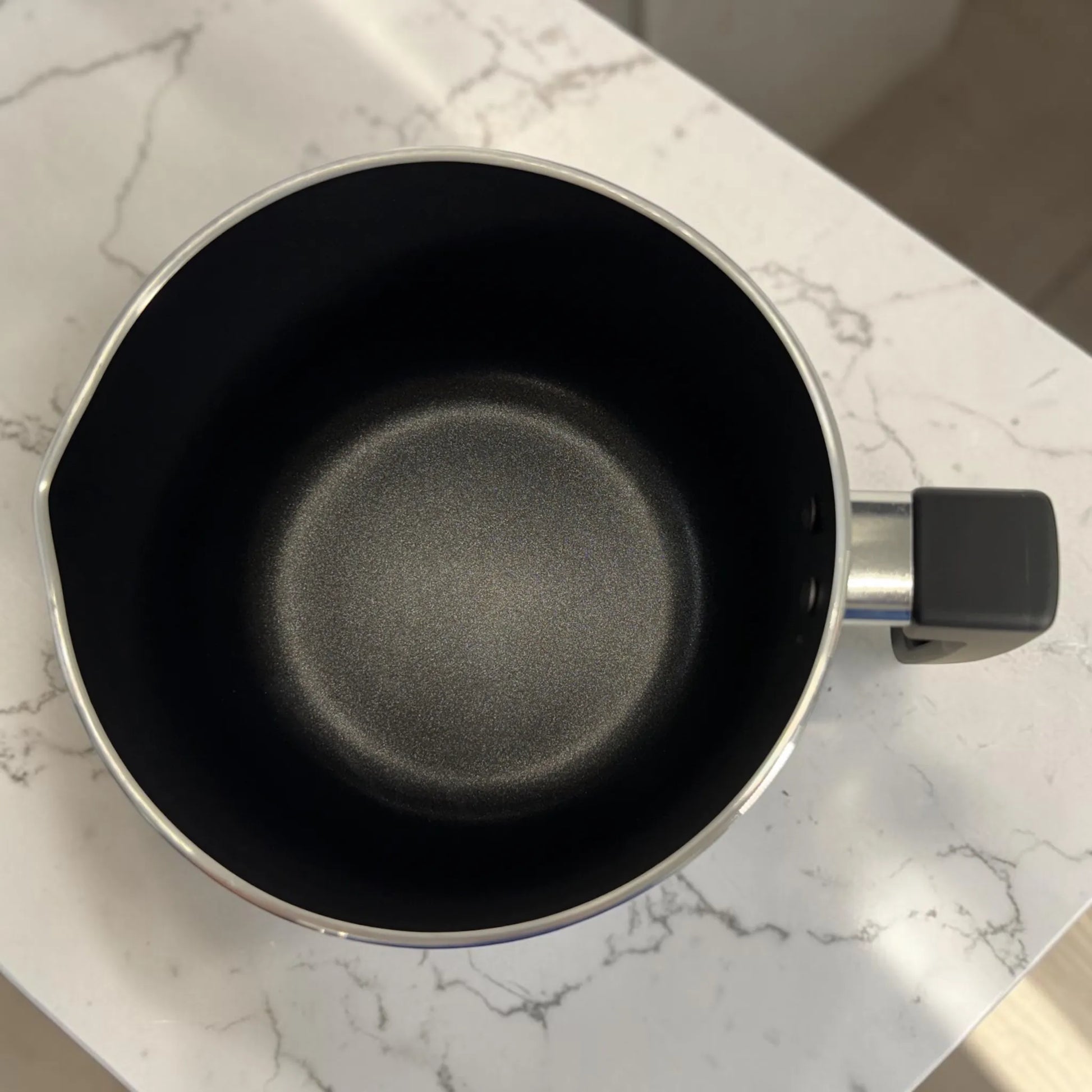 Interior del lechero ROCA negro con recubrimiento antiadherente, vista superior mostrando acabado uniforme.