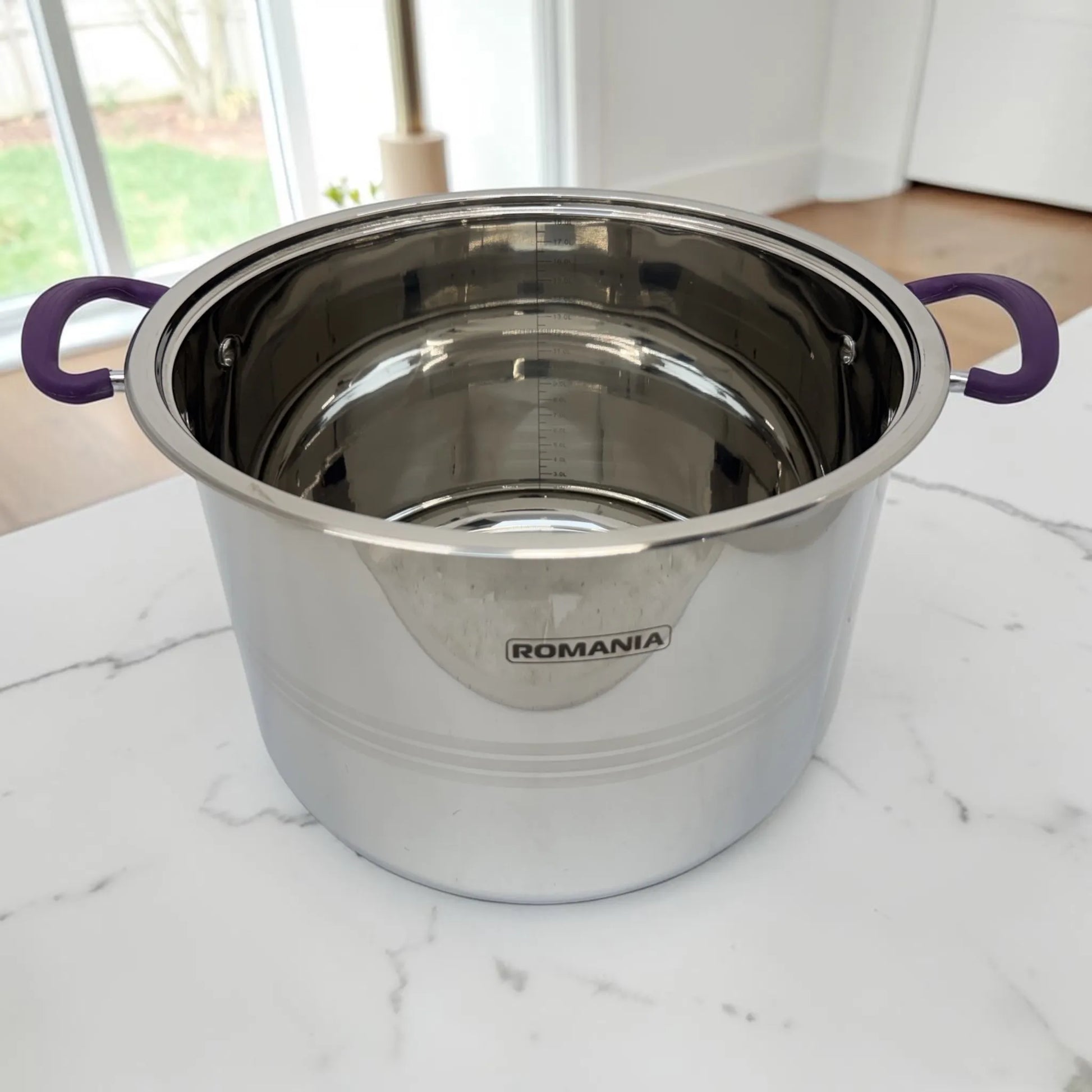 Interior de olla Romania de acero inoxidable con escala de medición visible y asas laterales color púrpura.